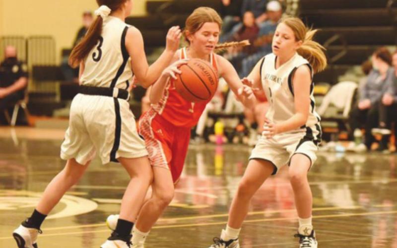 Seventh grade A team Lady Pirates, #3 Korbyn Whitworth and #2 Avery Harrington defend against an Orangefield Lady Bobcat.