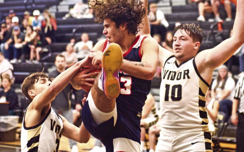 Battle under the basket Pirates Jose Guerrero-Evans, #3, and Camden Young, #10, battle a Hardin-Jefferson player for a rebound Monday at Pirate Gym.