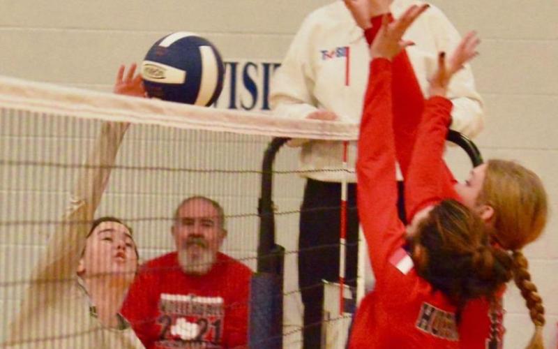Lady Pirate Brilie Cornelison attempts a return over the outstretched arms of two Lady Falcon defenders. Photo by Randall Luker
