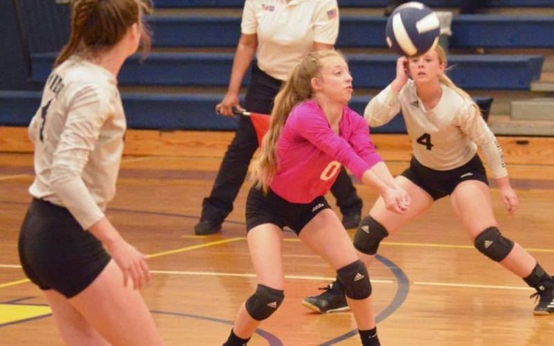 Lady Pirate Mia Robin, center, sets the ball on a Lady Falcon serve Monday. Brooklyn Bushelle, left, and Aarilynn Richardson, right, are also pictured. Photo by Randall Luker