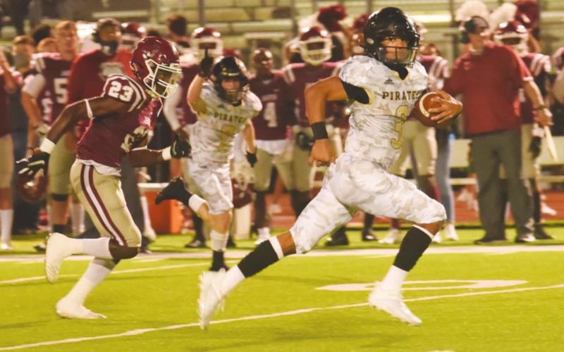 Pirate QB Quinten Root crosses midfield as he outruns his pursuers as he heads for a Pirate touchdown.
