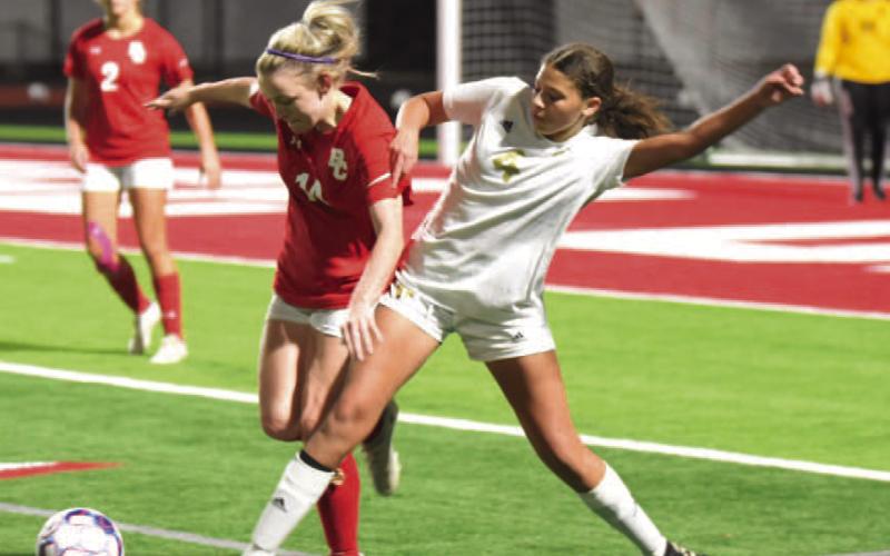 Kenya Correia fends off a Lady Cardinal as she passes to a teammate. Photo by Randall Luker