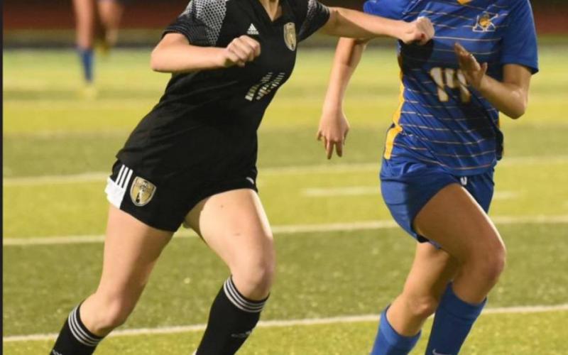 Lady Pirate Kaegan Stockwell fends off a Kelly threat as she dribbles the ball into Kelly territory. Photo by Randall Luker