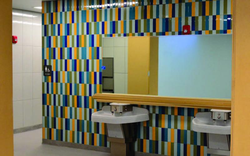 Modern lavoratories, colorful tiles, mirrors and open spaces highlight the restrooms at Oak Forst Elementary which will open to the student population january 9. Photo by Randall Luker