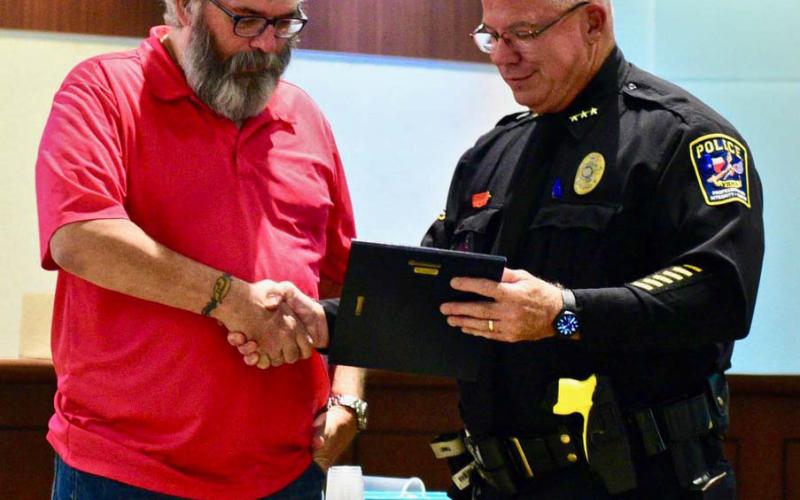 Vidor Police Chief Rod Carroll presents a plaque as he bids farewell to Officer Eric Meineke who is retiring after 13 years of service at the department.