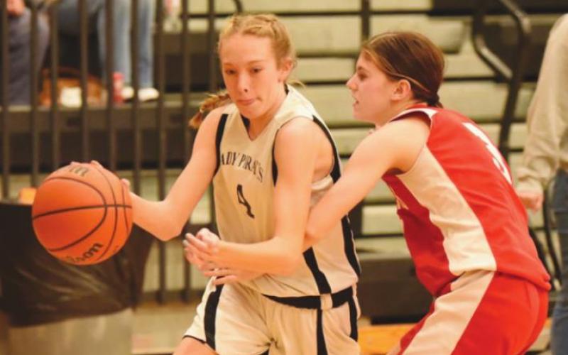 Lady Pirate Cierra Justice dribbles past a Lady Cardinal in the 8A game.