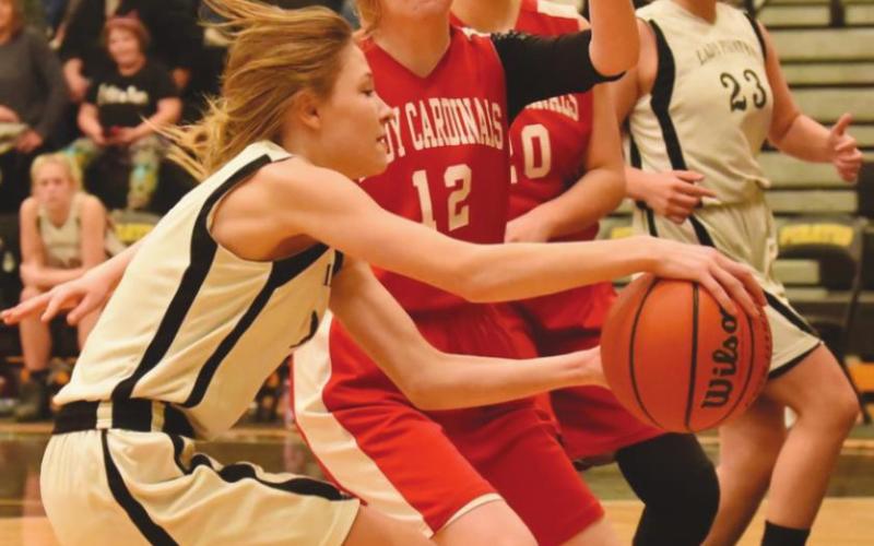 Lady Pirate Lauren Gibson hangs on to the ball under the net as teammate #23 Madison Perkins tries to get open in the 8A game