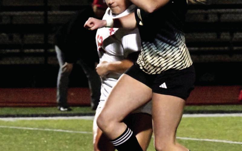 Quincy LaPray maintains control of the ball as a Lady Cardinal looks for a steal.