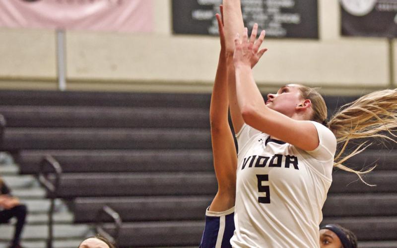 Vidor’s Raegan Stephenson shoots from under the basket in Friday’s 62-48 district win over the WOS Lady Mustangs as. Madison Perkins watches for the rebound.