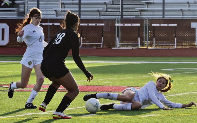 Jordyn Fowler tries to pass after she was knocked down with teammate Railei Mouton coming to her aid. Photo by Randall Luker