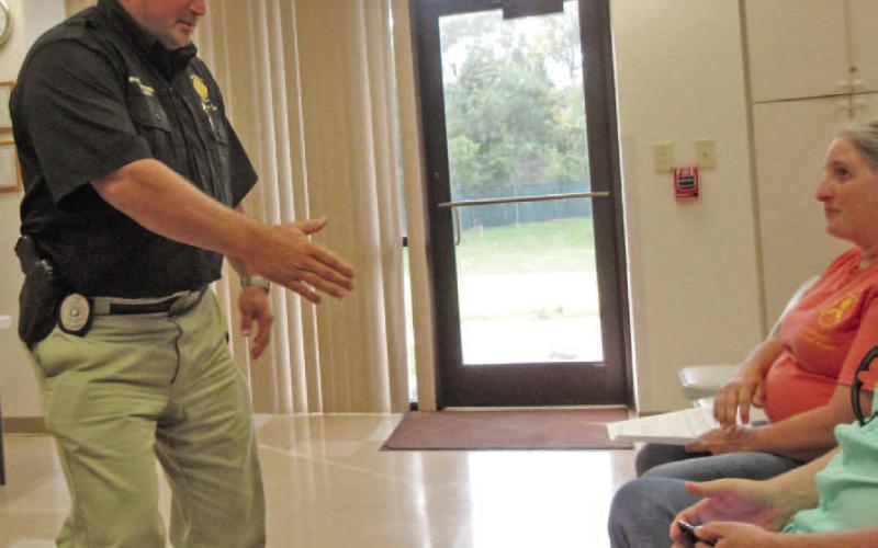OCESD#1 Fire Chief Bryant Champagne offers his hand in congratulations to OCESD#1 Acting Fire Chief Robert Smith as he prepares to leave his last Board of Commissioners meeting. Chief Champagne is resigning his Fire Chief position at the end of this month. Archive Photo