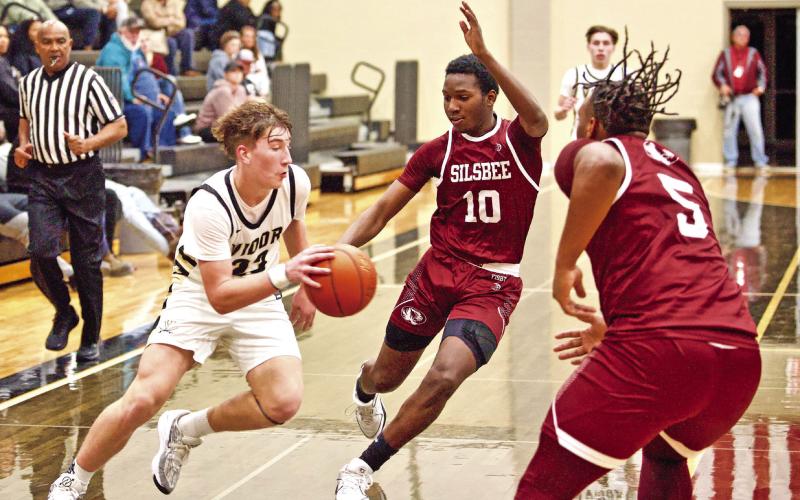 Caden Beavers make a break for the goal between two Tiger defenders.