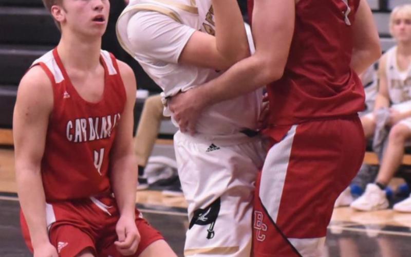 Bryce Loftin gets manhandled as he shoots in Tuesday’s game versus Bridge City. Photo by Randall Luker