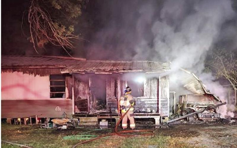 Smoldering remains An Orange County ESD#1 firefighter knocks down hotspots at a home in the 900 block of Pin Oak where two children were rescued by Vidor Police Officers by forcing a window air conditioner inside the home and pulling the children out the window. The cause of the fire was ruled accidental.