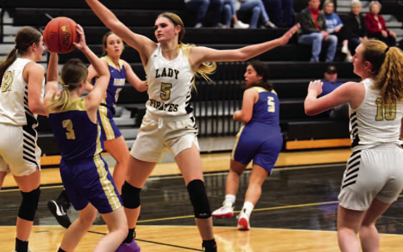 Raegan Stephenson #5 blocks a Hamshire Fannett Lady Horn in Tuesday’s non-district home game. Other Lady Pirates pictured are Madison Powell #21 and Natalie Morrison #10. Photo by Randall Luker
