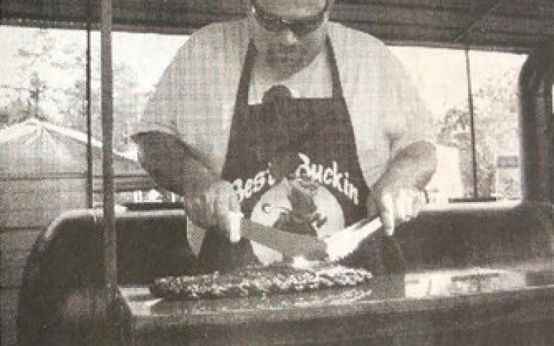 Ronnie Herrera of Team Best Buckin' Bar-B-Q gets ready to slice into a rack of tasty ribs as he prepares his entry for a past Texas Bar-B-Q Festival . Archive Photo