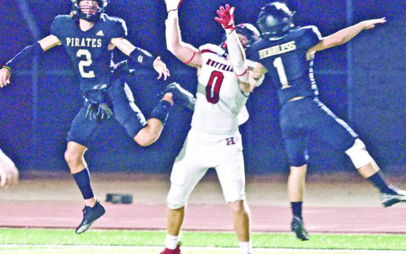 Pirate defenders Westin Baker, #1, and Blake Richards, #2, surround a Huffman receiver to break up a pass Friday at Pirate Stadium.
