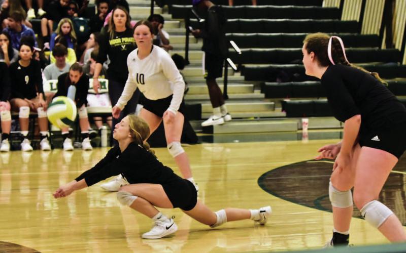 Mia Robin gets a dig versus LCM last week as #10 Carlie Abbott and Rylee Sherman look on. Photos by Randall Luker