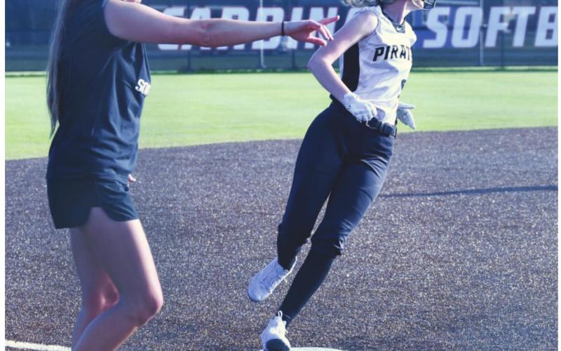 Lady Pirate Mallory Guillot keeps her eye on the play as she rounds third base under the direction of Coach Brooklyn Sampere.