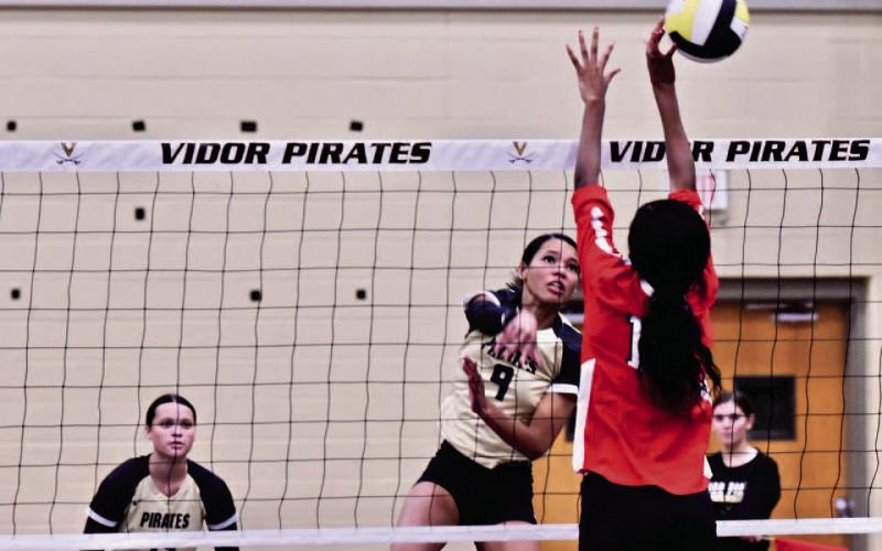 Madison Jones gets an overhand return past a Lady Titan Tuesday in Pirate Gym. Photo by Randall Luker