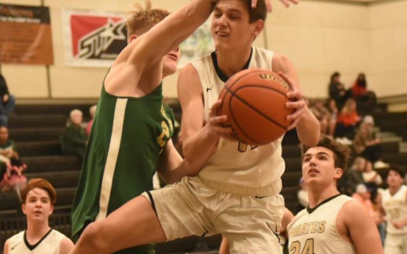 Branson Healy is fouled as he moves in for a shot in Tuesday’s home game versus the LCM Bears. The junior varsity Pirates lost 38-33 in a late change of lead. Photo by Randall Luker
