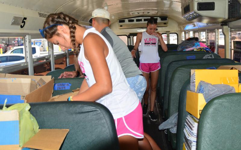 Student volunteers sort and stack the generous school supply donations at the Fill the Bus event. Photo by Randall Luker