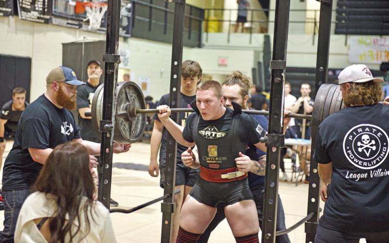 It’s a cinch Lady Pirate Layla Robinson gets a hand with her equipment as she belts up for the bench press at the Nederland High School Powerlifting meet Friday.