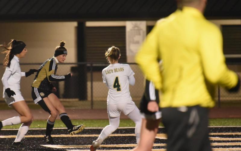 Lady Pirate Jaden Lee sends the ball between LCM defenders for a goal in the varsity match Friday. Photo by Randall Luker