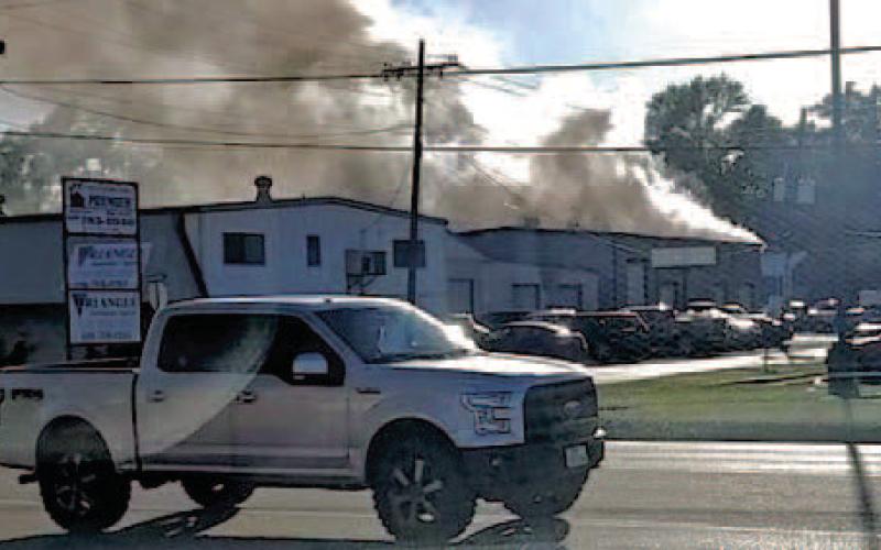 Billowing clouds of smoke pour from the C and R Transmission shop on Garland Street Tuesday after a lithium ion battery caught fire and spread through the building.