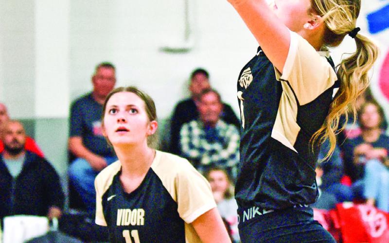 Madison Guillot sets the ball as Madison Powell readies for the return in Tuesday ’s bi-district playoff game in Anahuac.