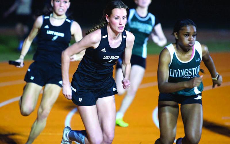 Jaden Lee, front, and Naomi Collier, rear, prepare to handoff in the 4X100 relay event. Photo by Randall Luker