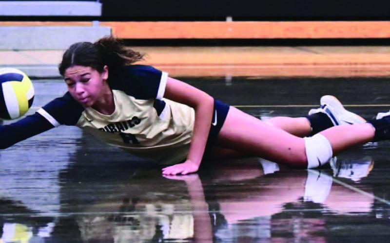 Lady Pirate Kenya Correia goes to the floor as she attempts a dive and dig versus the Lady Horns. Photo by Randall Luker