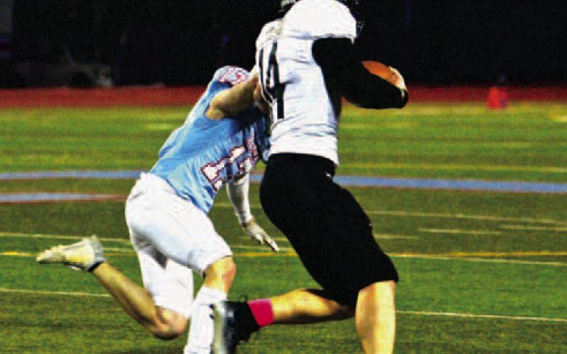 Jason Watson fights off a Raider tackler on his way to a big gain Friday.