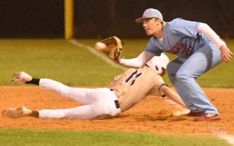 Ty Watson dives back to first base as the Lumberton pitcher tries to pick him off. Photo by Randall Luker