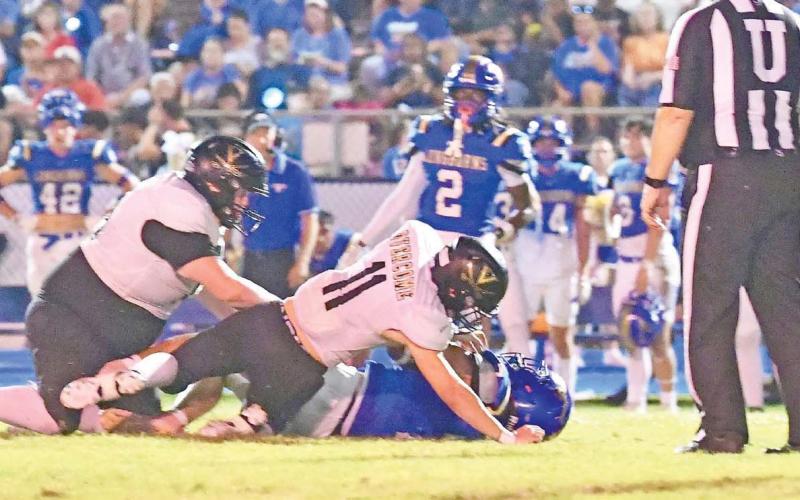 Brody Bloss, #11, and Owen Stephenson, #79, stop a H-F ball carrier Friday at Hamshire.