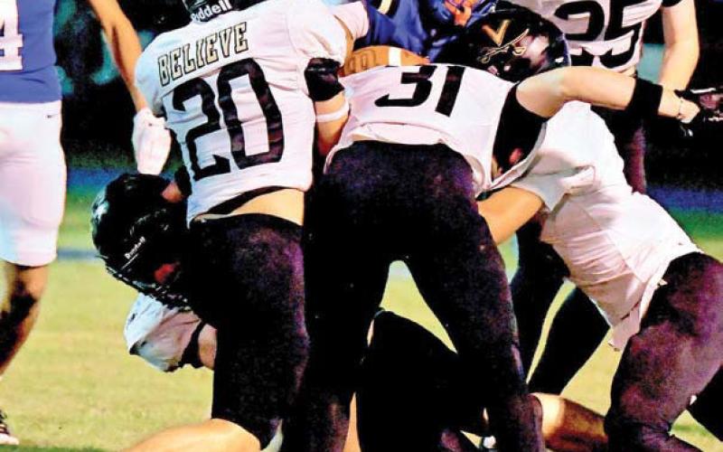 Several Pirate defenders gang tackle a Hamshire-Fannett back for a loss. Identifiable Pirates are #20 Braden Brinkley, #31 Kaiden Richard, and #25 Hyrum Huish.