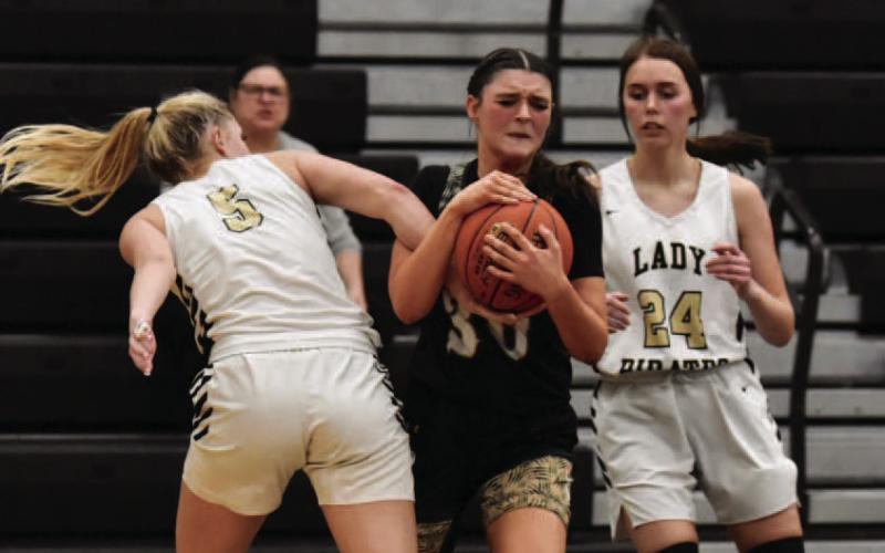 Lady Pirates Raegan Stephenson , left and Hailey Stelly, right, put the squeeze on a Lady Bear Tuesday in Pirate Gym. Photo by Randall Luker