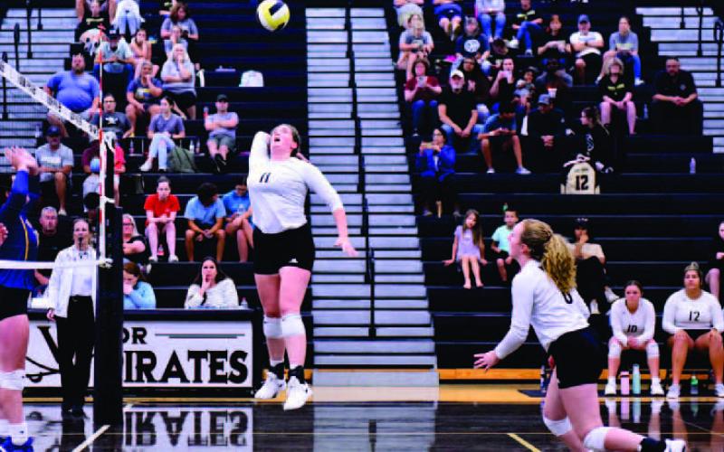 Rylee Sherman takes to the air for a return as Natalie Morrison runs toward the net. Photos by Randall Luker
