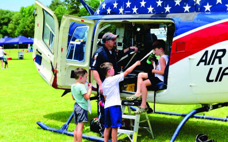 The 27th Annual Cops N Kids Picnic is set for June 9 with local first responders showcasing their tools of the trade and offering up close looks at their equipment in a personal and friendly environment. The annual event also offers lunch, rides, games, all free. In this photo from the 2022 event, children view a medical rescue helicopter and talk with the pilot. Photo by Randall Luker