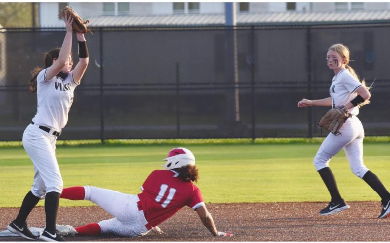 Lady Pirate shortstop Brilie Cornelison reaches for the throw as a Lady Cardinal slides into second base. Second baseman Gracie Matherne provides backup.