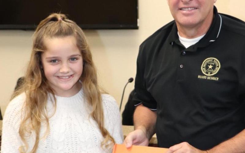 Presenting a book to the Oak Forest library in honor of Mr. David Camp was Jasmyn Smith.