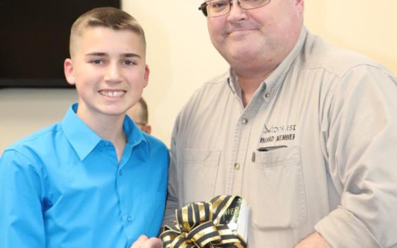 Drew Maines presented a book in honor of school board member Mr. Mike Marion. Drew is a student at Vidor Junior High.