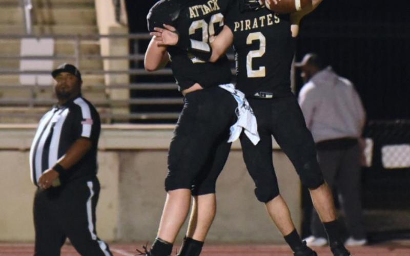 Pirate RB Layne Wilhelm, left, and QB Elisha Simmons celebrate Simmons’ touchdown in the end zone at Turner Stadium Friday. Photo by Randall Luker