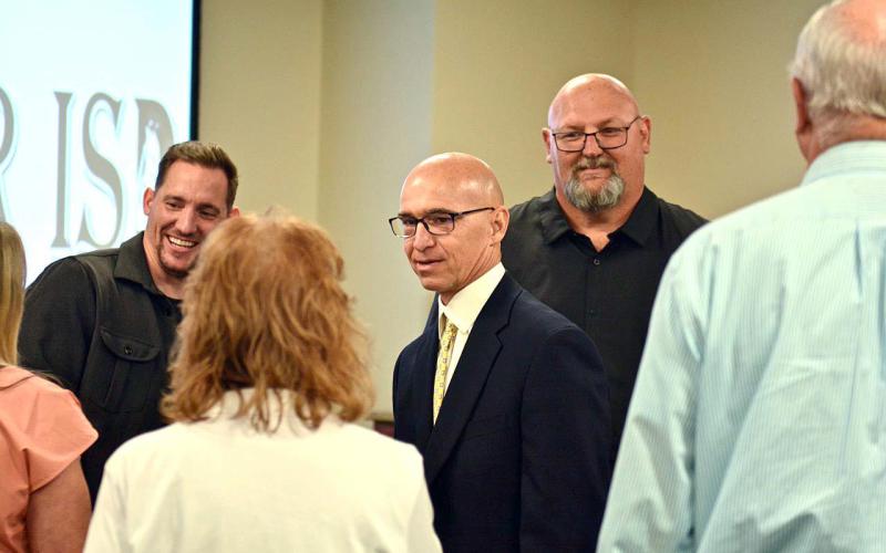 Dwayne Dubois, center, is congratulated after being named Vidor’s new Athletic Director/ Head Coach at Monday’s VISD Board of Trustees meeting held in the new Administration Building. Dubois said he was ready to get to work “as soon as possible”. Officially, his contract begins in July. Photo by Randall Luker