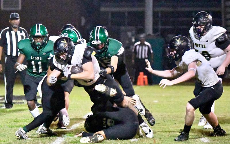 Brody Bloss fights through several Lion defenders to score.