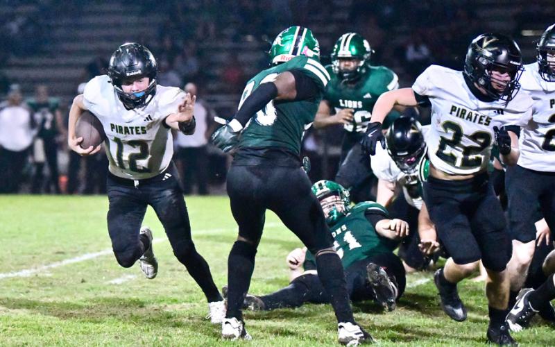 Jett Brucia sprints down the right side of the Pirate offensive line before turning upfield for a first down.