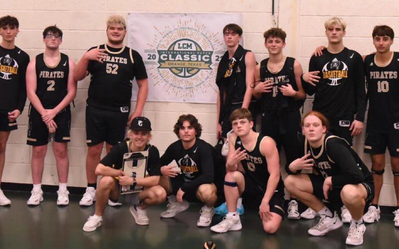 The Vidor Pirate varsity basketball team pose with their trophy following the end of tournament play that saw the Pirates win three of their four games. Photo by Randall Luker