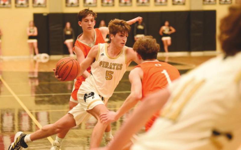 Joe Gardenhire makes his way between two Bobcats in Friday night action at Pirate Gym.