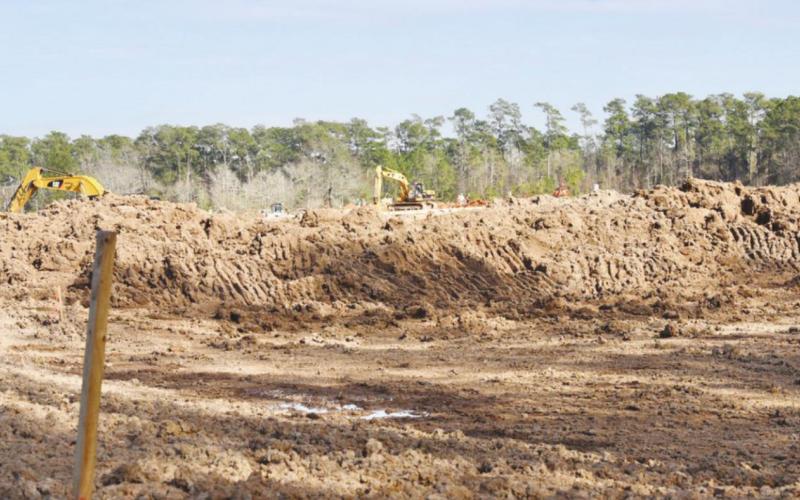 With trackhoes that dug it in the background, this exavation on the northwest corner of the campus was a prerequisite for rebuilding on the Oak Forest Elementary campus. When completed, the detention ponds will capture water runoff before it flows to neighboring properties. As an added bonus, Science classes may also use it as an outdoor lab and observation area.