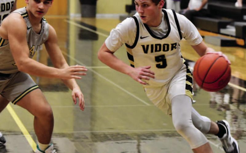 Bryce Loftin drives on the basket in Friday district game versus LCM. Photo by Randall Luker